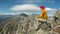 Tourist looks at the mountain landscape after climbing the peak. Motivation and achievement of their goals