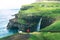 Tourist looks at the Mulafossur waterfall near Gasadalur on Faroe Islands