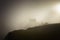 Tourist at Machu Picchu at sunrise in the fog