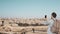 Tourist male takes photos of Jerusalem panorama. Man with backpack stands at skydeck edge with smartphone. Israel 4K.