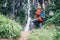 Tourist man with backback rest near the waterfall in rainy fores