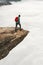 Tourist Man with backpack on Trolltunga rocky cliff