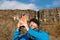 Tourist man enjoys view of Devil`s chimney waterfall, county Sligo, Ireland. Warm sunny day, Cloudy sky. Travel and outdoor