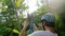 Tourist man in helmet slides a rope descent in tropical jungle.