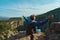 Tourist man sitting on cliff, enjoying view on canyon with high rocky walls