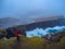 Tourist man taking photo on high cliffs, Faroe Islands, Denmark
