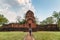 Tourist man walking into architectural of ancient ruins Prasat Muang Sing in historical park