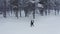 Tourist man walking trail forest in winter, aerial. Winter sport activity. Man tourist hiking snow winter forest snow