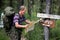 Tourist with a map near the signs. Inscriptions Tungur village, Kara Turek mountain.