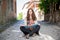 Tourist meditating girl sitting on the ground