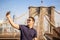 Tourist model taking a selfie on a Brooklyn Bridge