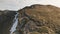 Tourist on mountain sun top aerial. People at autumn nature landscape. Snow and burnt grass at mount