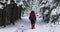 The tourist moves on a snowy road in the forest