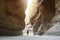 Tourist in narrow passage of rocks of Petra canyon in Jordan. UNESCO World Heritage Site. Way through Siq gorge to stone city