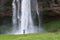 Tourist near a Seljalandsfoss waterfall in Iceland