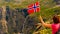 Tourist with norwegian flag on Trollstigen viewpoint
