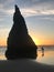 Tourist at Oregon beach takes a photo of popular sea stack.