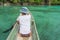 Tourist paddling on traditional wooden canoe on blue lagoon in the remote Togean Islands, Central Sulawesi, Indonesia.