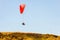Tourist pair flight on a red paraglider over the hill