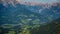 Tourist paragliding over valleys surrounded by the Alps in Austri