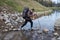 Tourist passes affluent stream using trekking poles