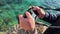 Tourist photographs transparent sea. Man standing on cliff, holding camera