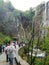 Tourist in the Plitvice lakes. Waterfalls, lake cascades, canyon and wooden bridge in Plitvice Lakes National Park