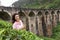 A tourist poses in a tea plantation near the famous nine-arch bridge in Sri Lanka. Tourism in picturesque places