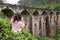 A tourist poses in a tea plantation near the famous nine-arch bridge in Sri Lanka. Tourism in picturesque places