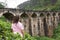 A tourist poses in a tea plantation near the famous nine-arch bridge in Sri Lanka. Tourism in picturesque places