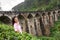 A tourist poses in a tea plantation near the famous nine-arch bridge in Sri Lanka. Tourism in picturesque places