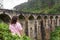 A tourist poses in a tea plantation near the famous nine-arch bridge in Sri Lanka. Tourism in picturesque places