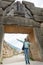 Tourist posing under famous Lion gate entrance.