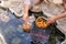 Tourist putting a basket of eggs into and boiling in mineral and natural hot water