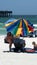 Tourist putting up a shade umbrella on the beach