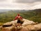 Tourist in red black sportswear, green backpack on view point watch landscape.