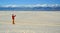 A tourist in red clothes on a background of sand dunes photographs
