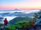 Tourist with red outdoor windcheater in dwarf pines. Autumn hilly landscape