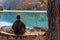 Tourist is resting on the bench near beautiful mountains lake with turquoise water and colorful forest. Tourism, trekking, hiking