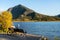 Tourist resting on wooden bench, relaxing at Vermilion Lakes lakeshore in autumn. Banff National Park