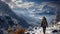 A tourist rock climber stands on the top of a snowy mountain