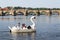 Tourist sailing on pedal boats on Vltava river near Charles bridge in Prague, Czech Republic