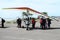 Tourist in shade of wing of hang-glider on Airshow