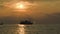 Tourist ship leaving pier at sunset