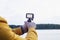 Tourist shoots a video on an action camera against the backdrop of nature and the river. Close-up of a white screen mockup on the