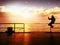 Tourist sit on mole handrail and takes pictures. Man enjoy morning at sea