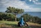 Tourist sitting on the grass near a tree opposite the Black Sea on the southern coast of the Crimea peninsula