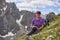 Tourist sitting resting on sloping mountain glade