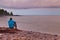 Tourist sitting on rocky shore of Lake Superior and enjoy scenic view