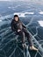 Tourist sitting on the surface of the cracks of the frozen Lake Baikal in the winter season in Siberia, Russia. Lake Baikal is the